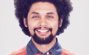 A man with a beard and mustache smiling for the camera.