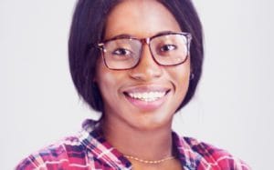 A woman wearing glasses and smiling for the camera.