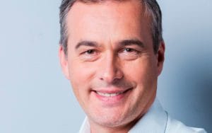 A man with grey hair and a white shirt