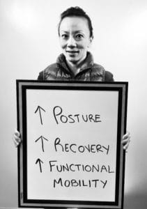 A man holding up a board with arrows pointing to the words posture, recovery and sleep.