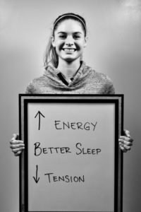 A woman holding up a sign that says " energy better sleep ".
