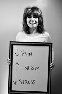 A woman holding up a sign with arrows pointing to the center of each arrow.