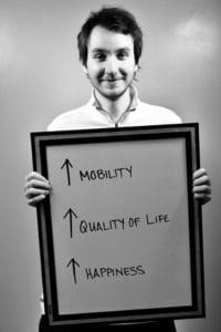 A man holding up a sign with arrows pointing in different directions.