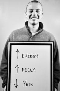 A man in a hoodie holding up an energy sign.