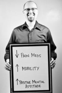 A man holding up a sign that says pain meds and mobility.