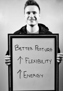A man holding up a board with the words better posture and flexibility written on it.
