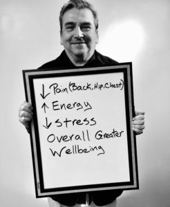 A man holding up a whiteboard with directions for how to manage stress.