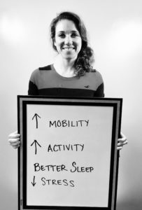 A woman holding up a sign with arrows pointing in different directions.