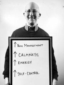 A man holding up a sign with arrows pointing to the bottom of each word.