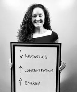 A woman holding up a sign with the word headaches and concatenation written on it.