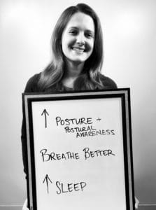 A woman holding up a sign with words written on it.