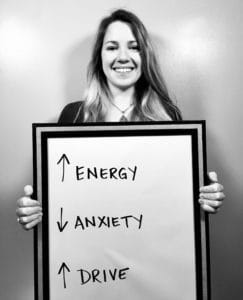 A woman holding up an energy sign and anxiety arrow.