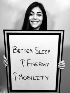 A woman holding up a sign that says better sleep and energy.