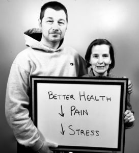 A man and woman holding up a sign.