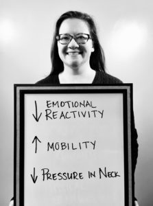 A woman standing next to a board with arrows pointing in different directions.