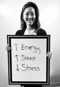 A woman holding up a sign with the words energy, sleep and sleep.