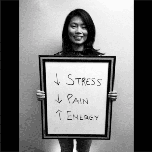 A woman holding a sign with four words written on it.