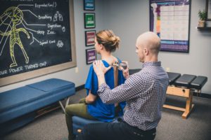 A man and woman sitting in front of a chalkboard.