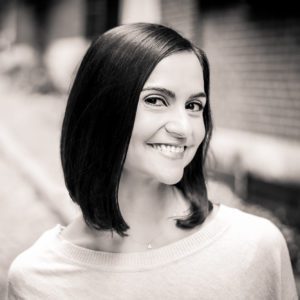 A woman with long hair smiles for the camera.