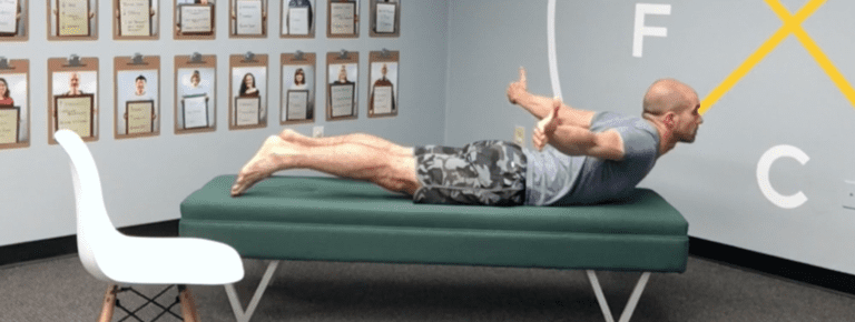 A man laying on top of a bed with his feet up.