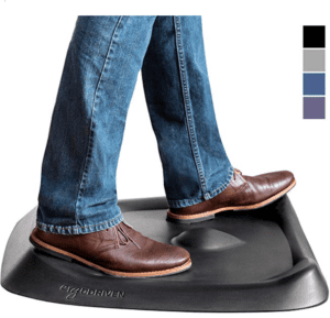 A person wearing jeans and brown shoes standing on a black surface.