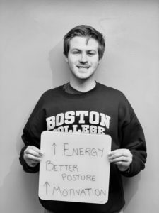 A man holding up a sign that says " boston college 1 energy savings ".