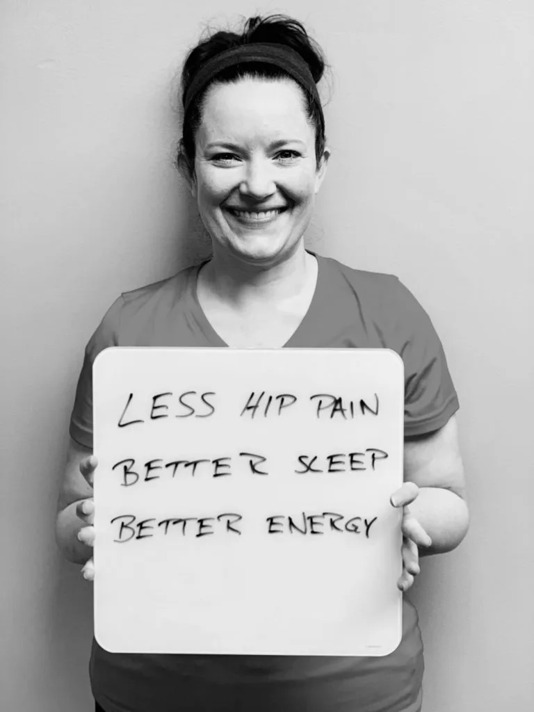 patient story- A woman holding up a sign that says less hip pain, better sleep and better energy.