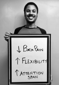 A man standing in front of a board with the words back pain and flexibility written on it.