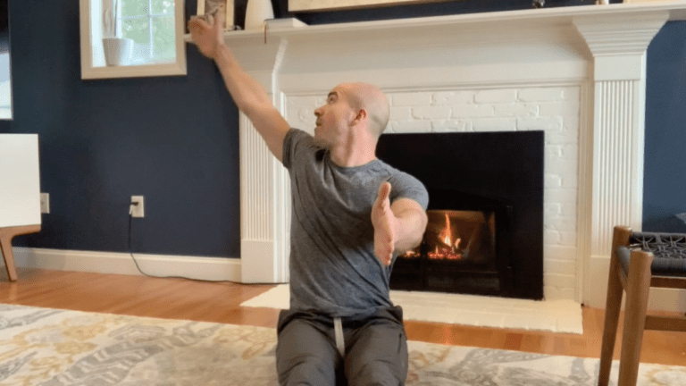 A man sitting on the ground in front of a fireplace.