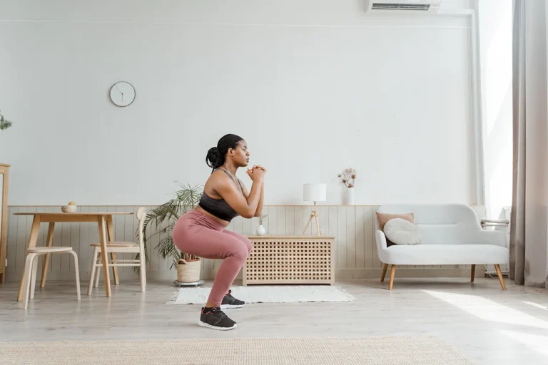 woman squatting in her living room - why you should be squatting everyday of your life