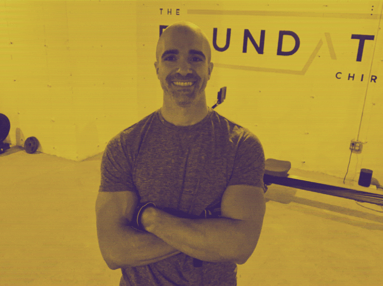 A man standing in front of a yellow wall.