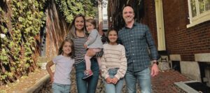 A family posing for a picture in front of some trees.