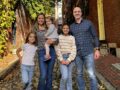 A family posing for a picture in the fall.