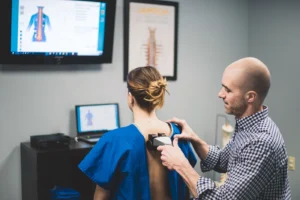 chiropractor using nervoscope on patient's spine.