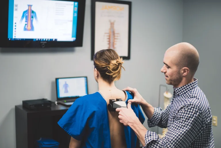 chiropractor using nervoscope on patient's spine.