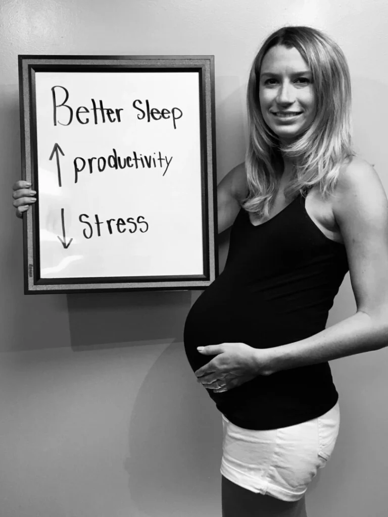 patient story - pregnant woman holding a sign that says increased productivity and reduced stress- neuro-structural chiropractic adjustment results for pregnant women