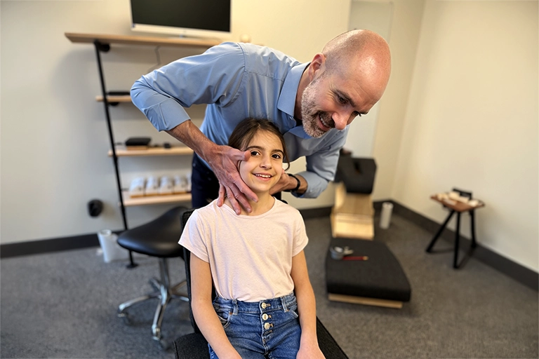 pediatric chiropractic care - Dr robert mirandola adjusting a young girl's neck