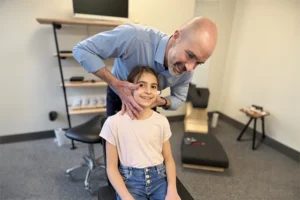 pediatric chiropractic care - Dr robert mirandola adjusting a young girl's neck