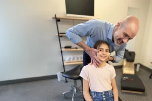 pediatric chiropractic care - Dr robert mirandola adjusting a young girl's neck