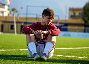 teen athlete sitting in a soccer field - pediatric chiropractic care