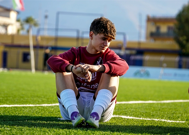 teen athlete sitting in a soccer field - pediatric chiropractic care