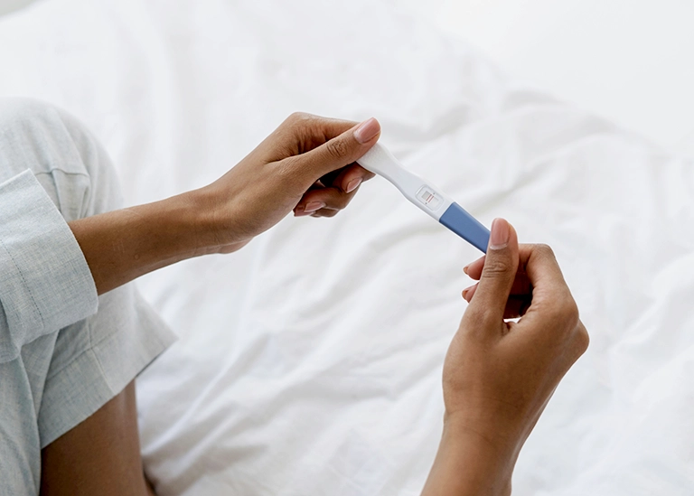 hands holding a pregnancy test -chiropractic care for pre-conception planning