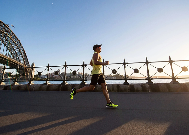 male runner running across a bridge - chiropractic care for athletes in MA