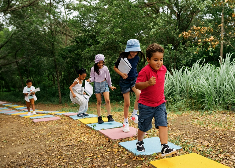 school-age children playing outside in a playground- pediatric chiropractic care