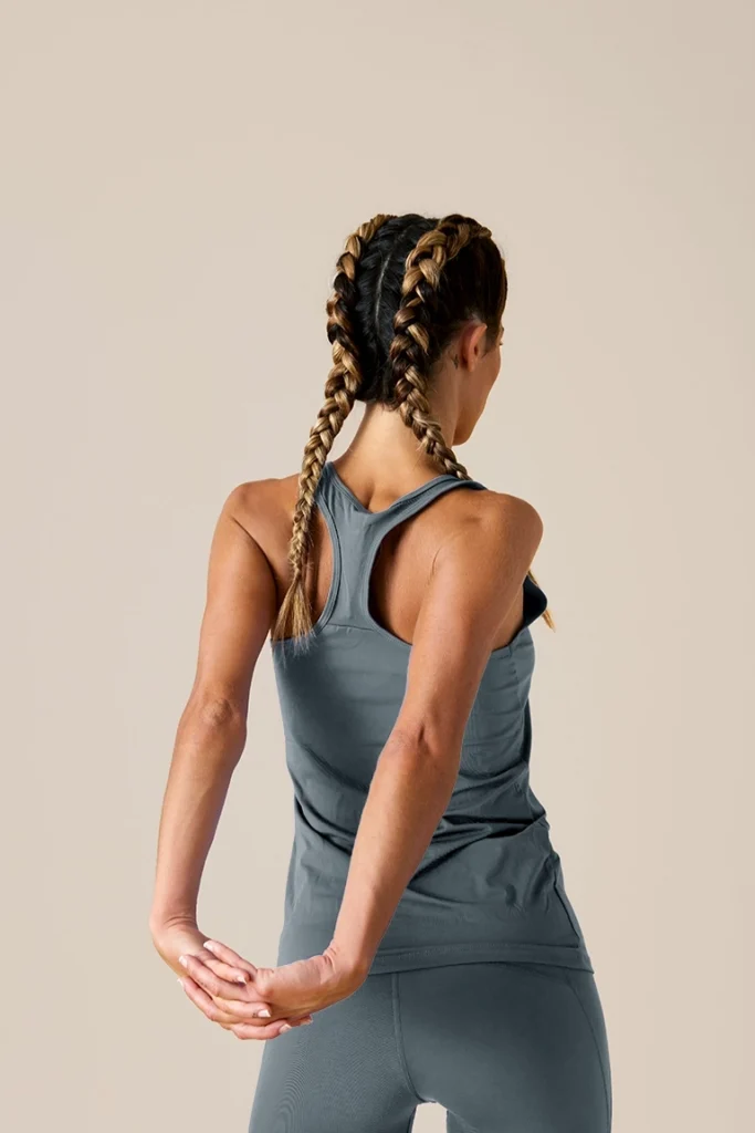 athlete stretching her arms behind her back - chiropractic care for athletes