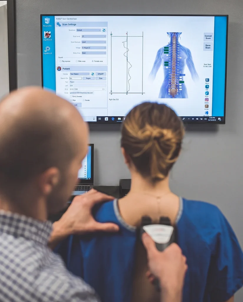 chiropractor Dr Mirandola using the nervoscope to measure spinal alignment